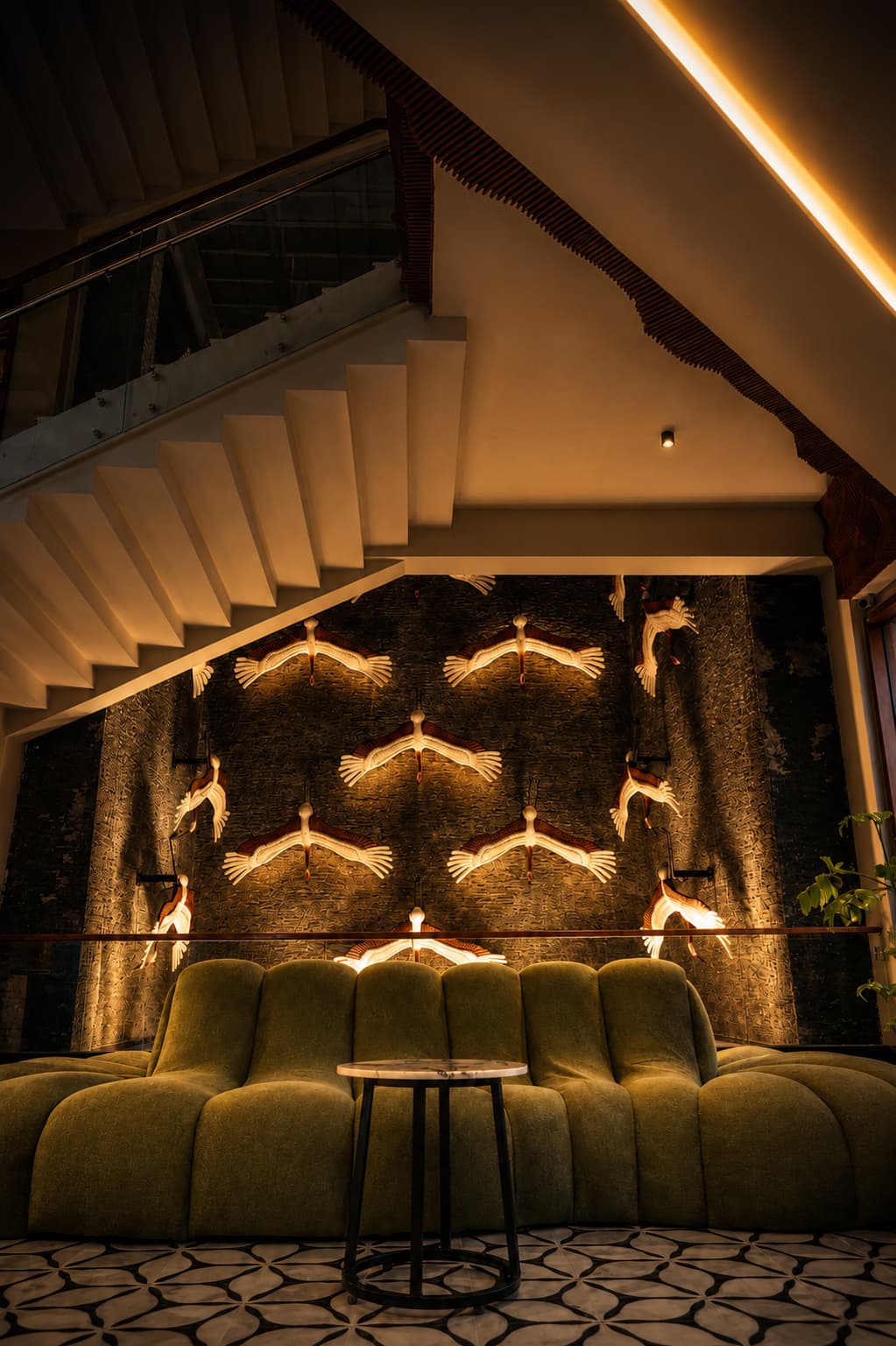 The lobby staircase and illuminated crane wall at Grand Unicorn Club
