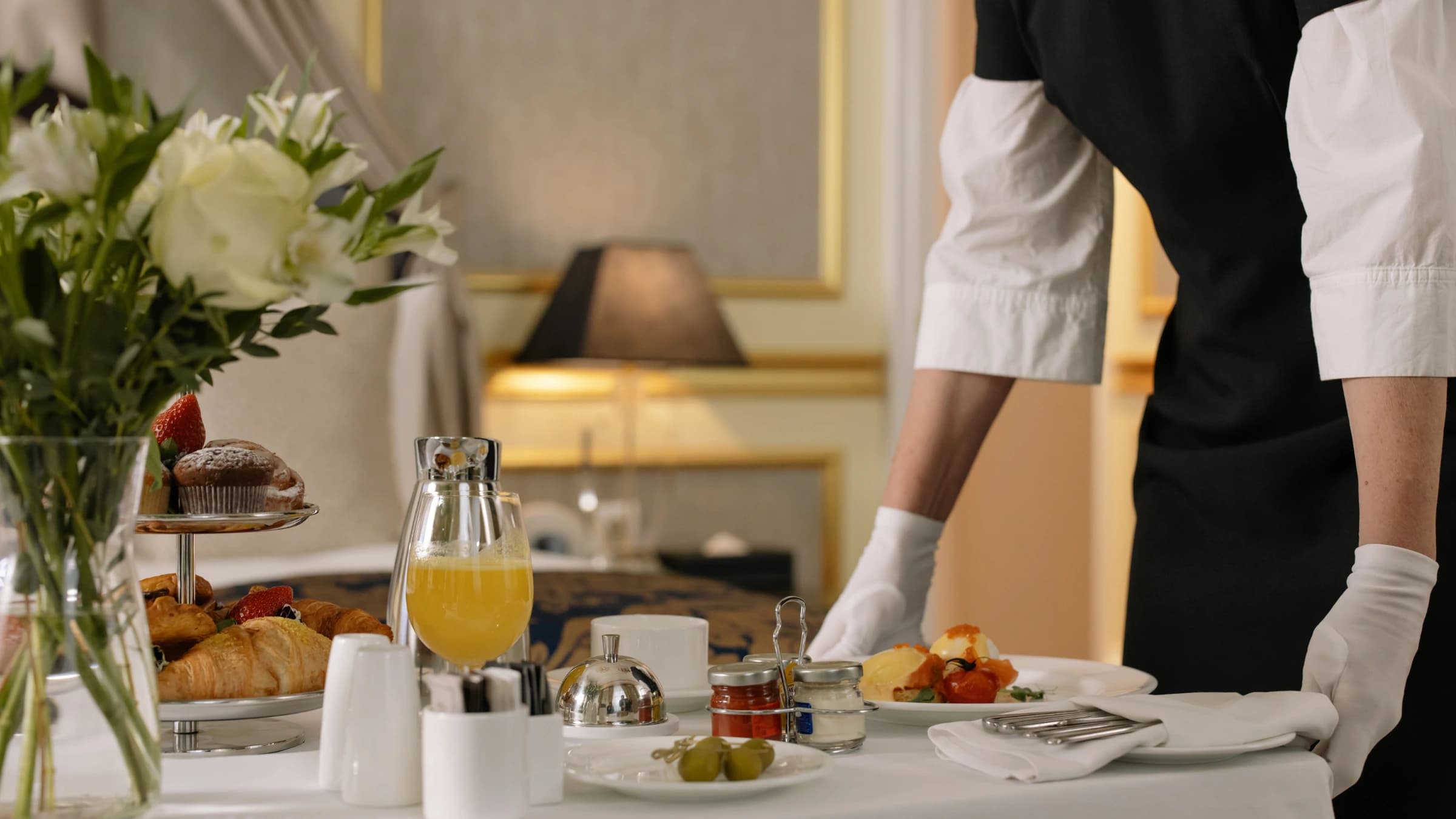 A server presenting a plated dish at a Royal Swiss Lahore catered table